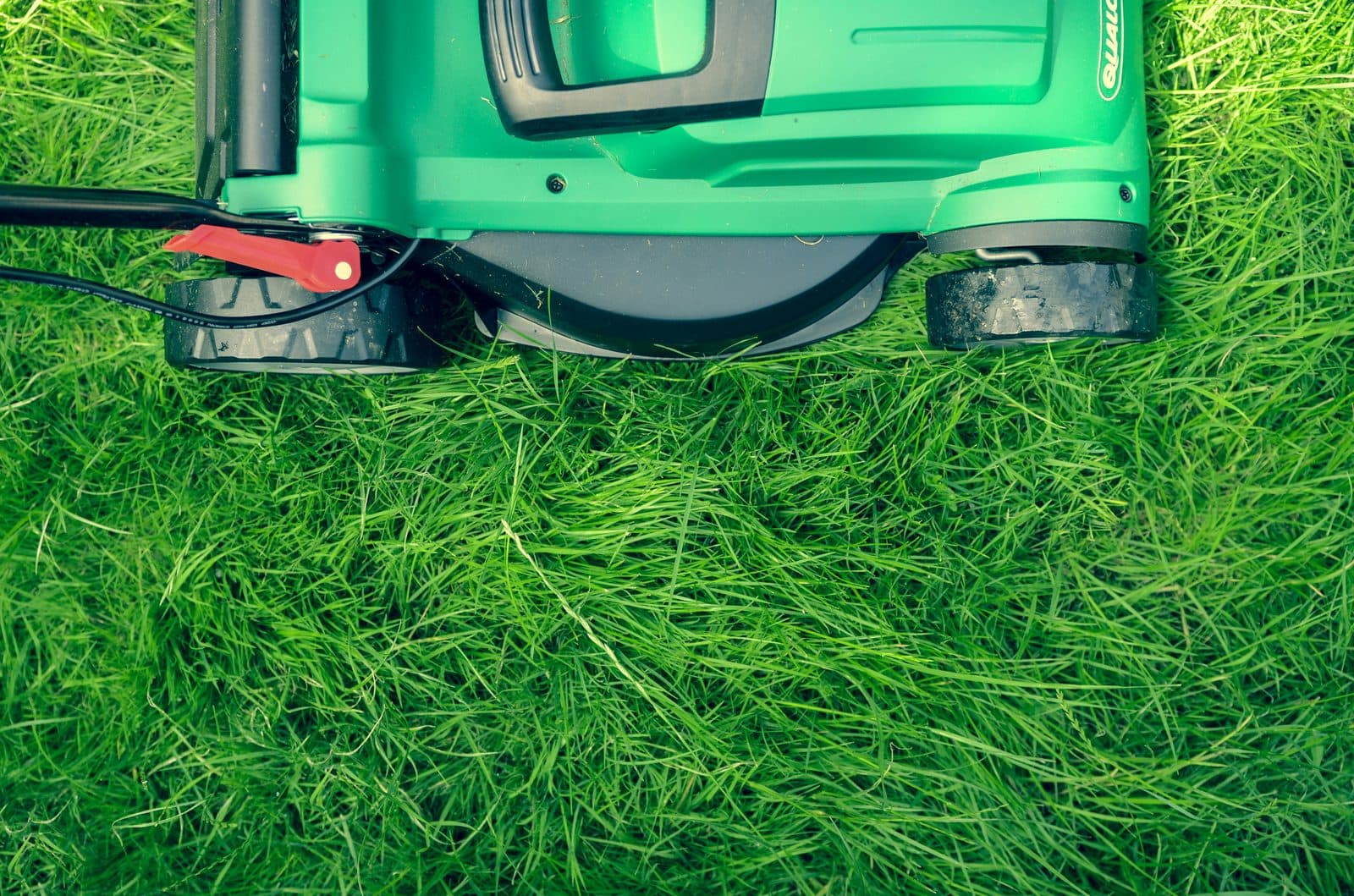 Crew member mowing a Bermuda grass lawn in Surf City