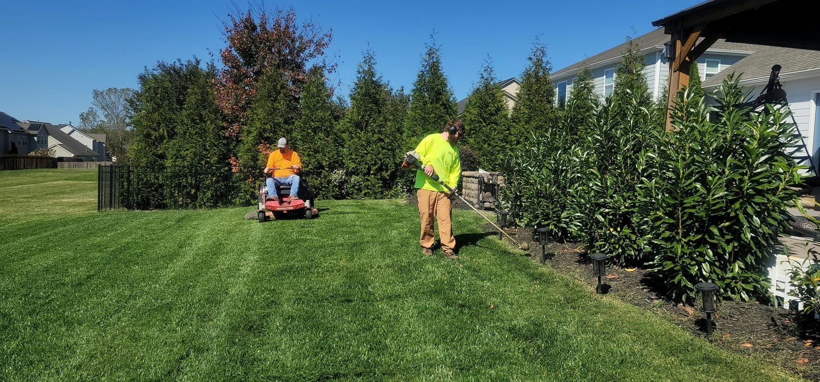 Surf Town Lawn Co. crew mowing and edging a residential lawn in Surf City NC